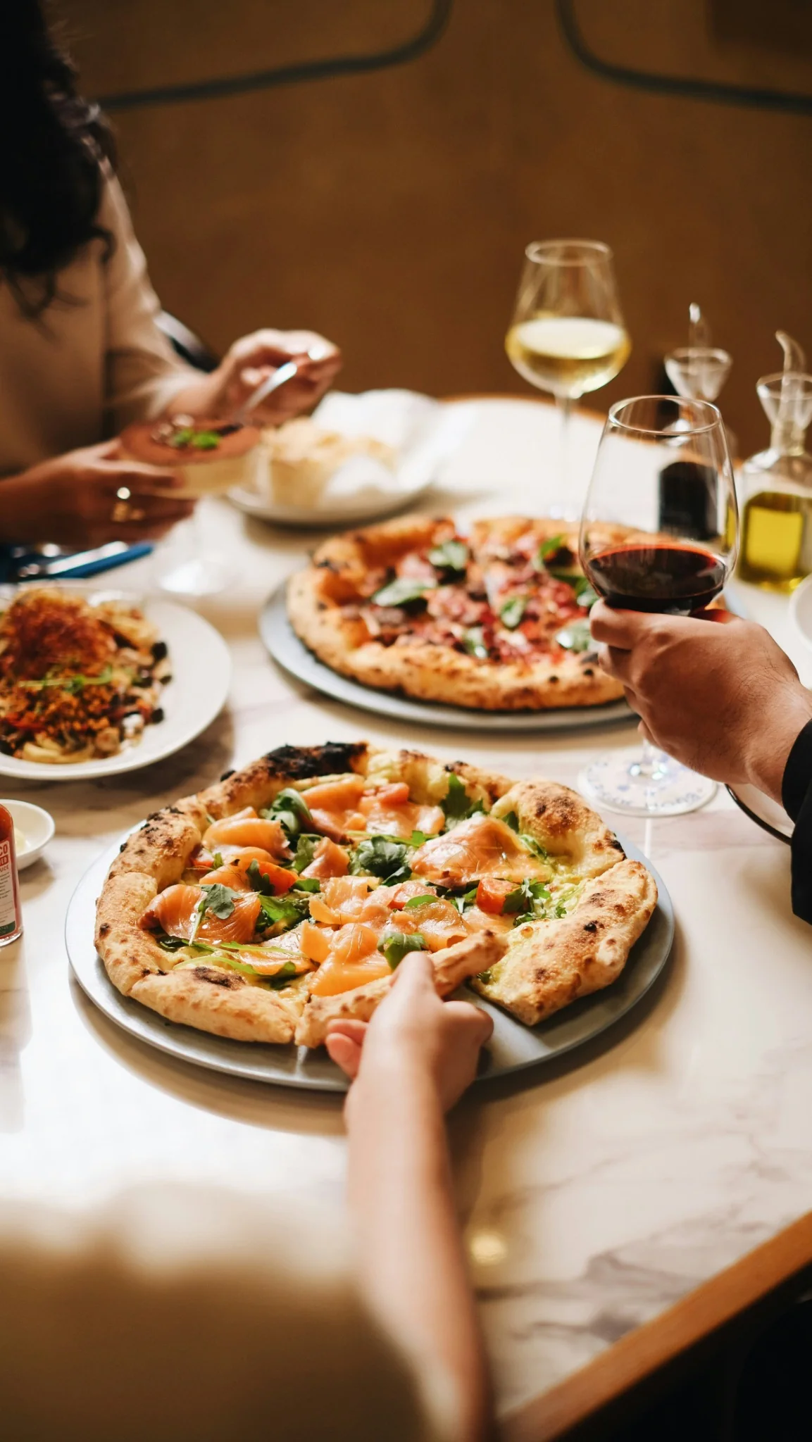 Παρέα απολαμβάνει χειροποίητη pizza με κρασί